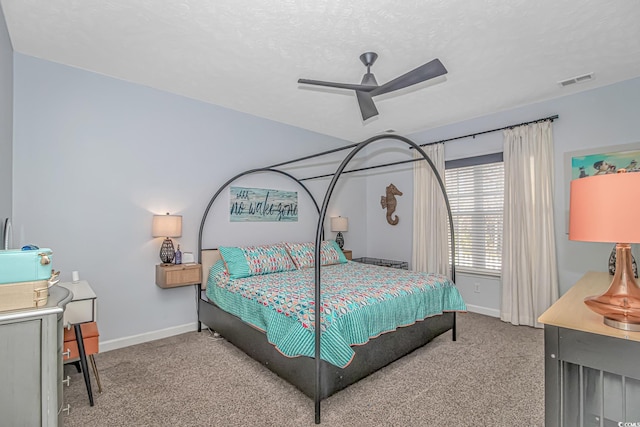 bedroom with ceiling fan, carpet floors, and a textured ceiling