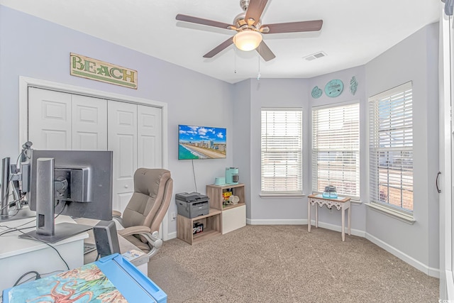 carpeted office space with ceiling fan and a healthy amount of sunlight