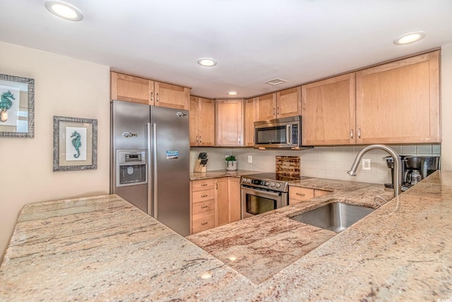 kitchen featuring sink, stainless steel appliances, light stone counters, decorative backsplash, and light brown cabinets