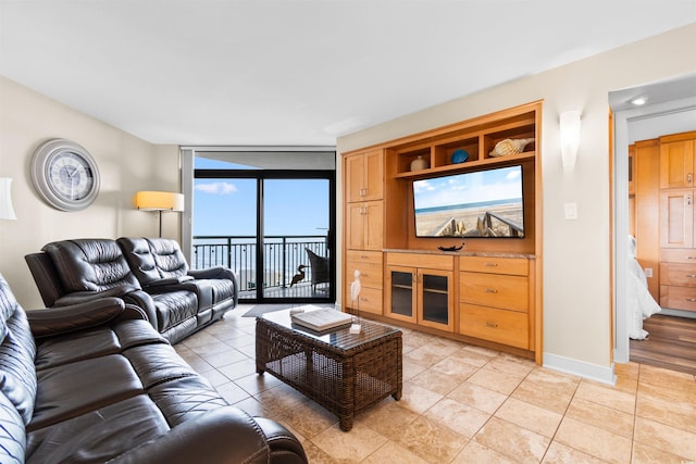 living room with light tile patterned flooring and a wall of windows