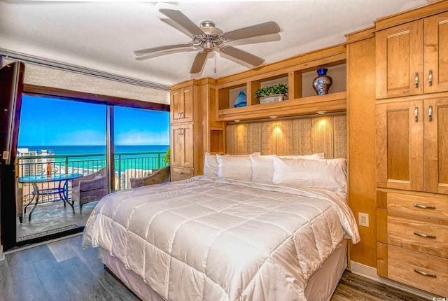 bedroom with ceiling fan, a water view, access to outside, and dark hardwood / wood-style flooring