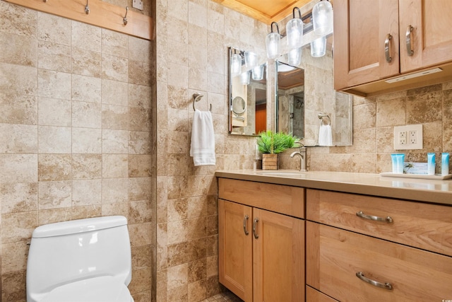 bathroom featuring vanity, toilet, tile walls, and backsplash