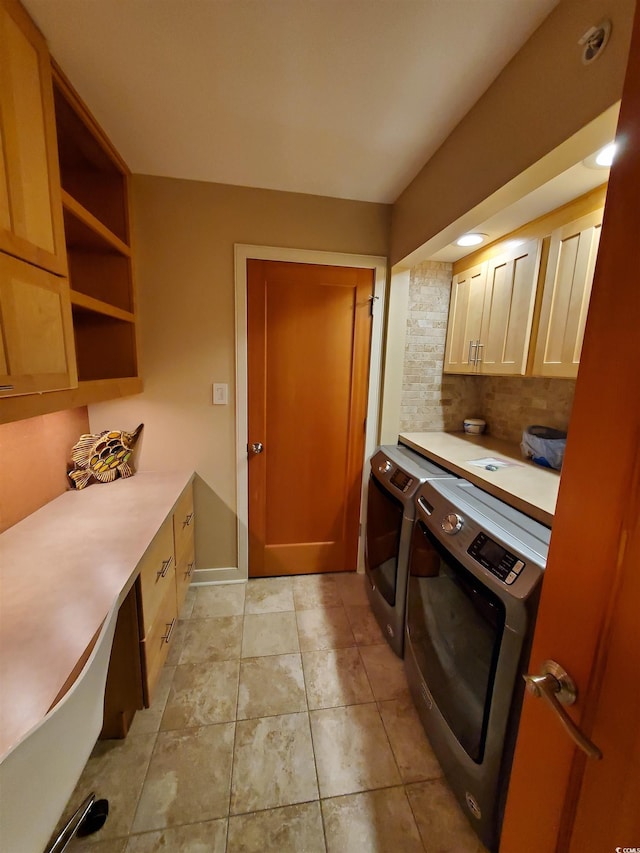 laundry room featuring light tile patterned floors, washing machine and dryer, and cabinets