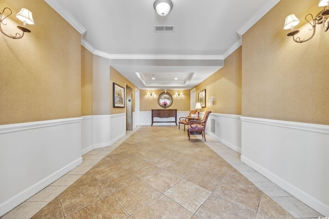 hall featuring a tray ceiling and ornamental molding