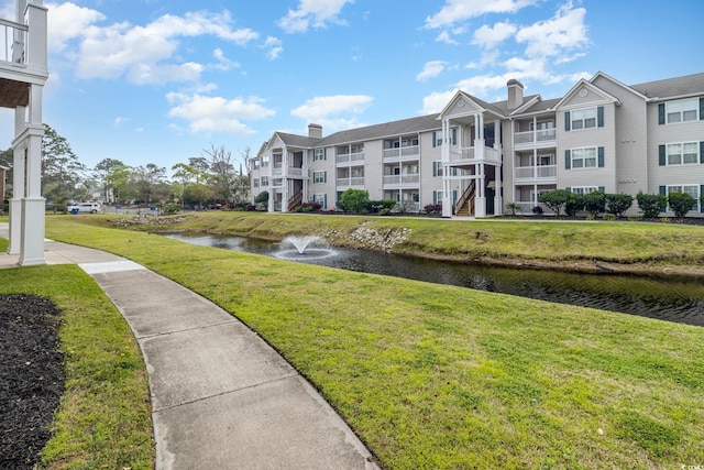 view of community featuring a water view and a lawn