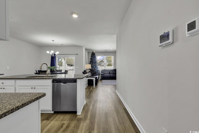 kitchen with dishwasher, sink, a chandelier, pendant lighting, and white cabinets