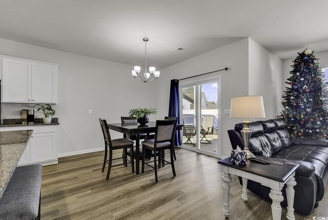 dining room with hardwood / wood-style floors and an inviting chandelier