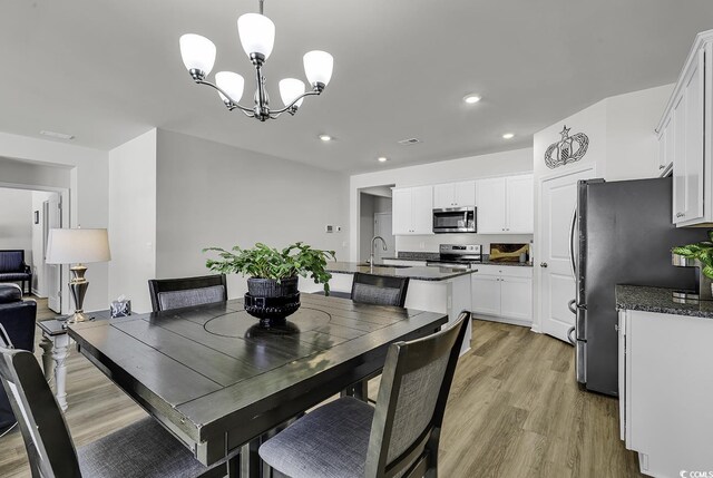 dining room featuring light hardwood / wood-style flooring, a chandelier, and sink