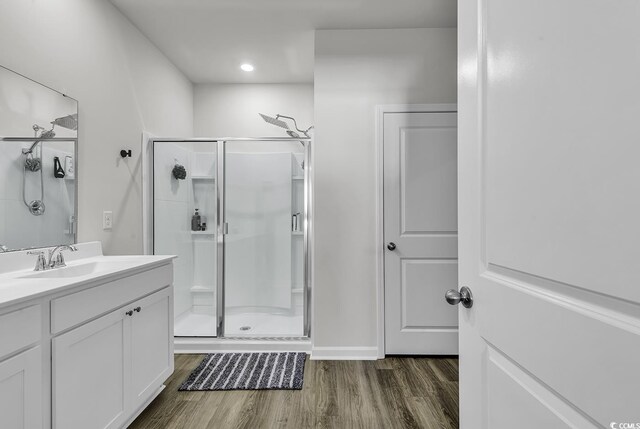 bathroom featuring wood-type flooring, vanity, and walk in shower