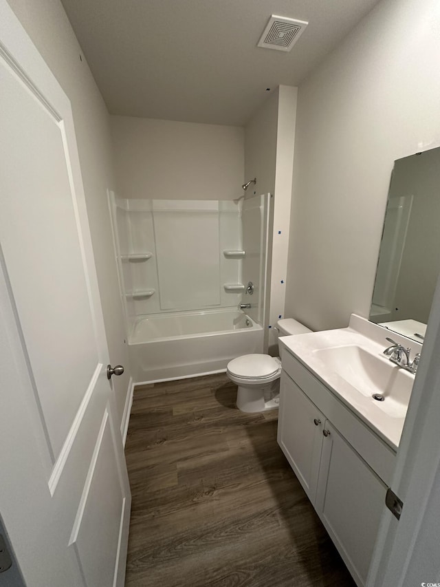 full bathroom with toilet, vanity, wood-type flooring, and tub / shower combination