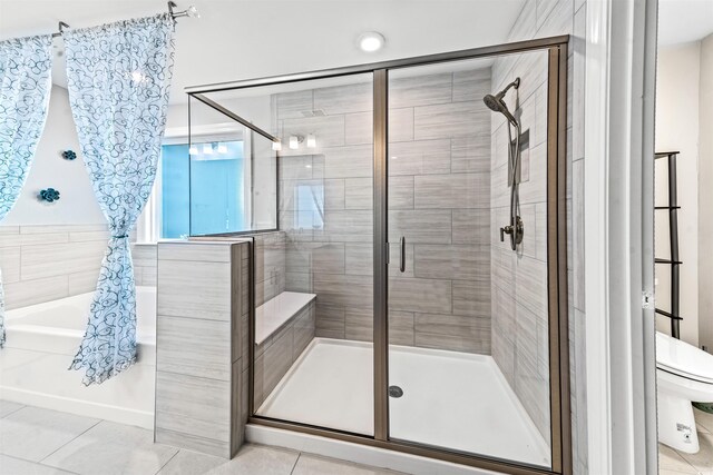 bathroom featuring tile patterned flooring, separate shower and tub, and toilet