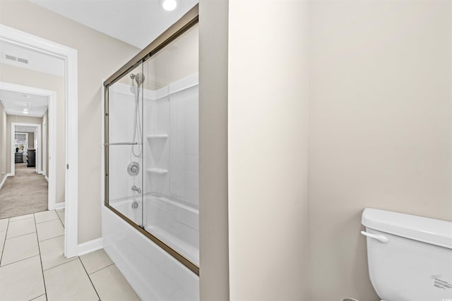 bathroom featuring tile patterned floors, bath / shower combo with glass door, and toilet