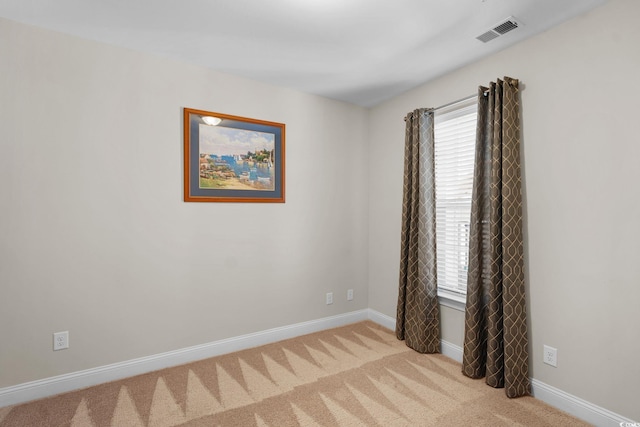 spare room featuring light colored carpet