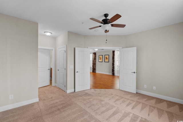 unfurnished bedroom featuring ceiling fan and light colored carpet