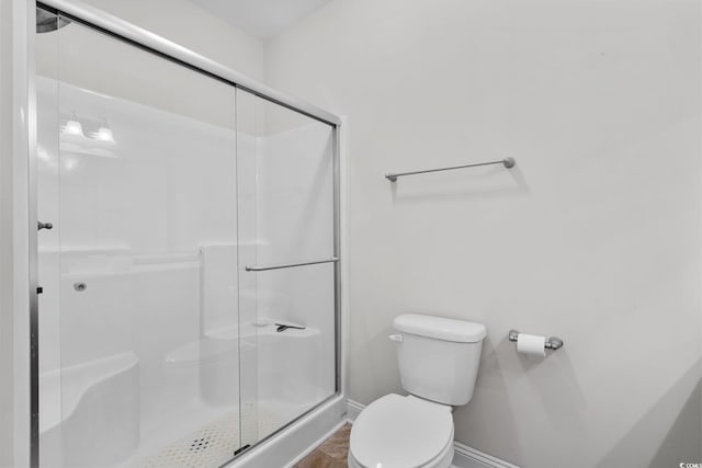 bathroom with toilet and an enclosed shower