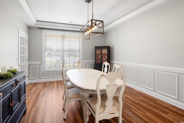 dining room featuring dark hardwood / wood-style flooring, an inviting chandelier, and ornamental molding