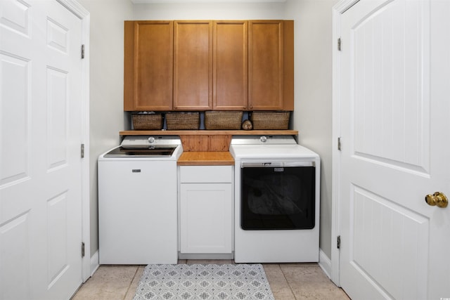 washroom featuring light tile patterned floors, cabinets, and independent washer and dryer