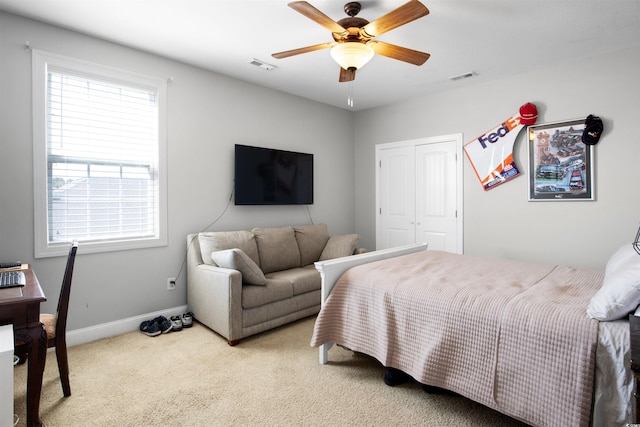 carpeted bedroom with ceiling fan and a closet