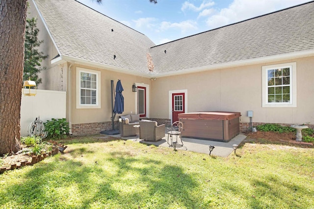 rear view of house with a lawn, an outdoor living space, a patio, and a hot tub