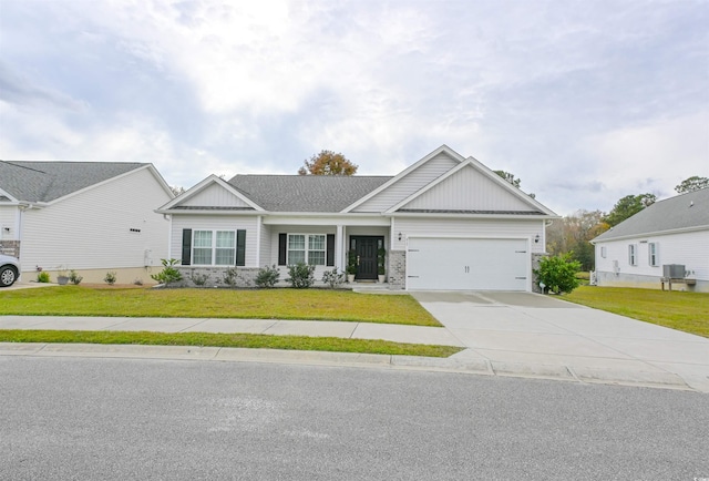 view of front of property featuring a front yard, central AC, and a garage