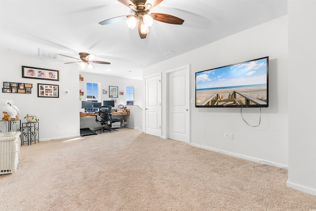 carpeted home office featuring ceiling fan