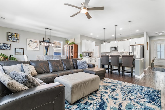 living room with ceiling fan and dark wood-type flooring