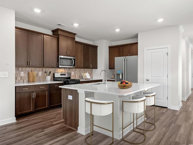 2039 Copper Creek Loop, Longs, SC 29568 - kitchen with appliances with stainless steel finishes, a kitchen bar, an island with sink, sink, and backsplash