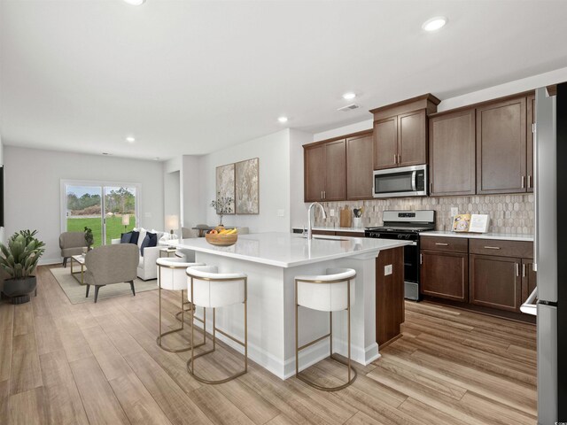 2039 Copper Creek Loop, Longs, SC 29568 - kitchen featuring appliances with stainless steel finishes, tasteful backsplash, an island with sink, sink, and a kitchen breakfast bar