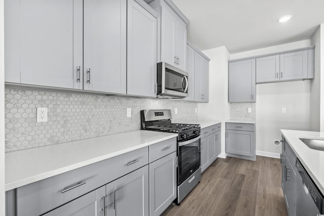 2039 Copper Creek Loop, Longs, SC 29568 - kitchen featuring dark hardwood / wood-style flooring, decorative backsplash, gray cabinetry, and stainless steel appliances
