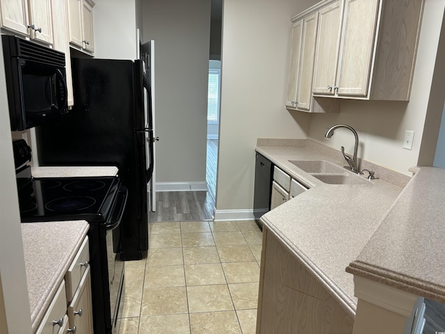 kitchen with light tile patterned floors, sink, and black appliances