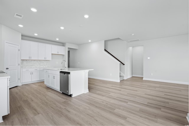 kitchen with white cabinetry, dishwasher, sink, an island with sink, and light hardwood / wood-style floors