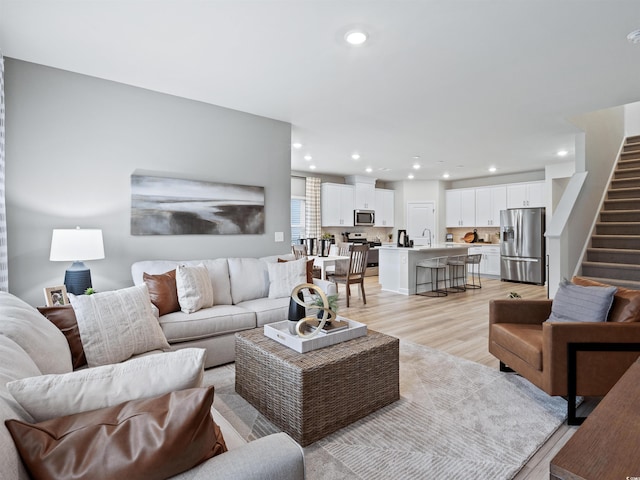 living room featuring sink and light hardwood / wood-style flooring