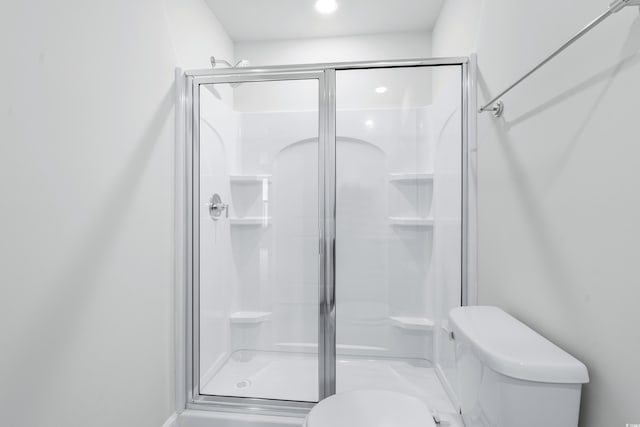 bathroom featuring walk in shower and toilet