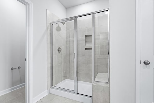 bathroom featuring a shower with door and tile patterned floors