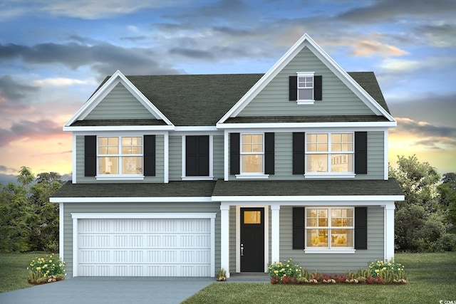 view of front of home with a garage and a yard