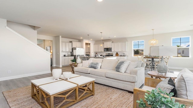 living room with an inviting chandelier and light hardwood / wood-style flooring