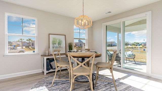 dining area with a notable chandelier and light hardwood / wood-style floors