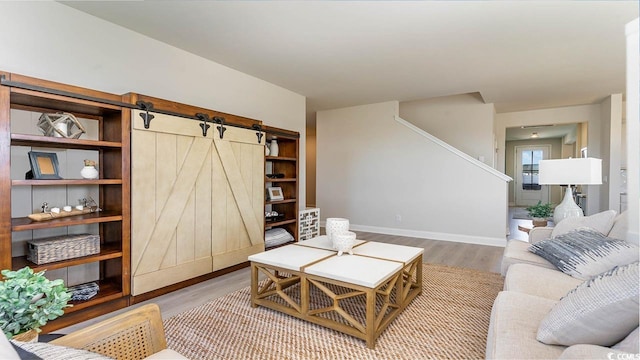 living room featuring a barn door and hardwood / wood-style flooring