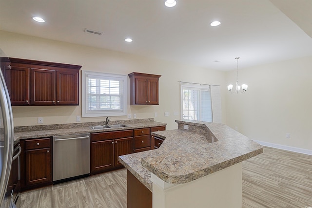 kitchen featuring appliances with stainless steel finishes, sink, decorative light fixtures, an inviting chandelier, and light hardwood / wood-style flooring