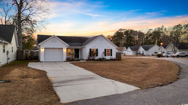 ranch-style home with a yard and a garage