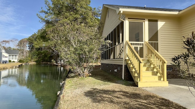 view of side of property featuring a water view and a sunroom