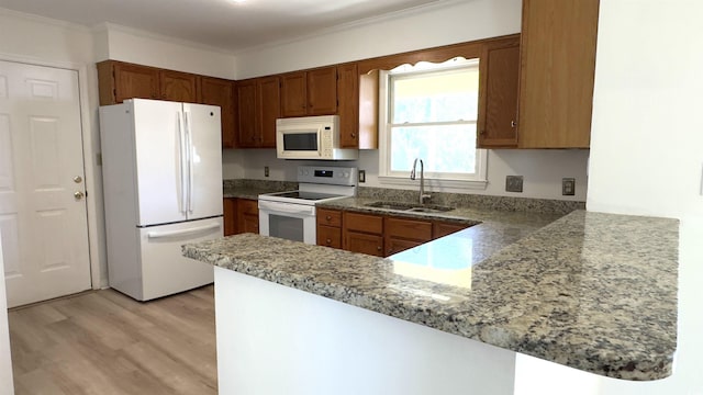 kitchen featuring sink, kitchen peninsula, stone counters, white appliances, and light hardwood / wood-style floors