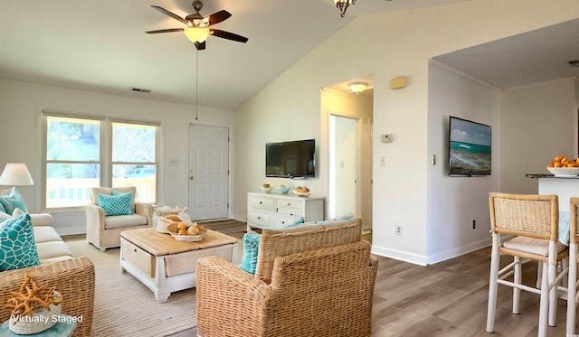 living room with hardwood / wood-style flooring, vaulted ceiling, and ceiling fan