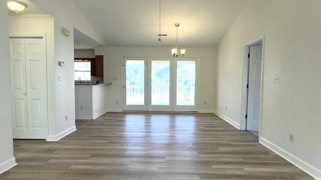 interior space featuring lofted ceiling, light hardwood / wood-style floors, and an inviting chandelier