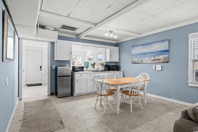 dining space with beamed ceiling and light tile patterned floors