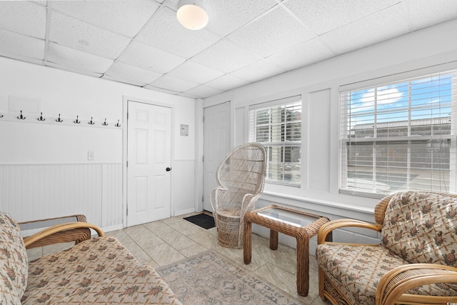 sitting room with a paneled ceiling and light tile patterned floors