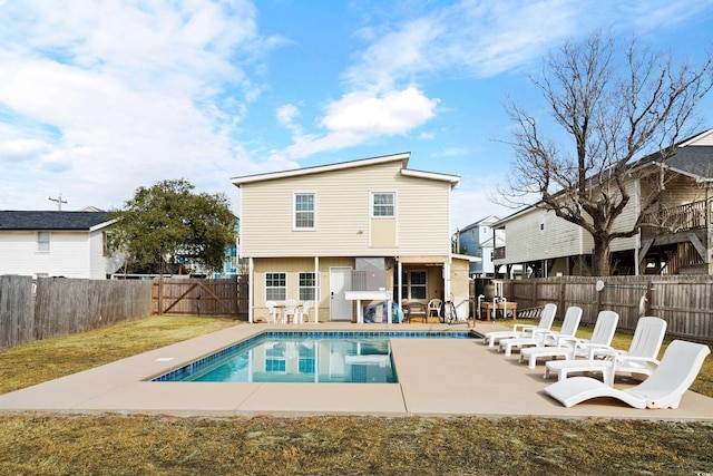 back of property featuring a fenced in pool, a patio area, and a yard