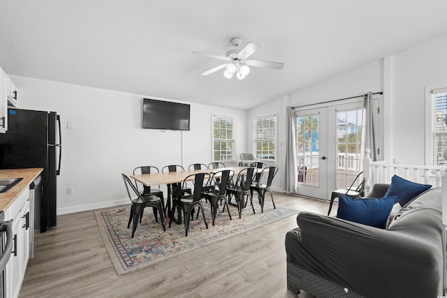 dining area with ceiling fan, french doors, light hardwood / wood-style floors, and a textured ceiling