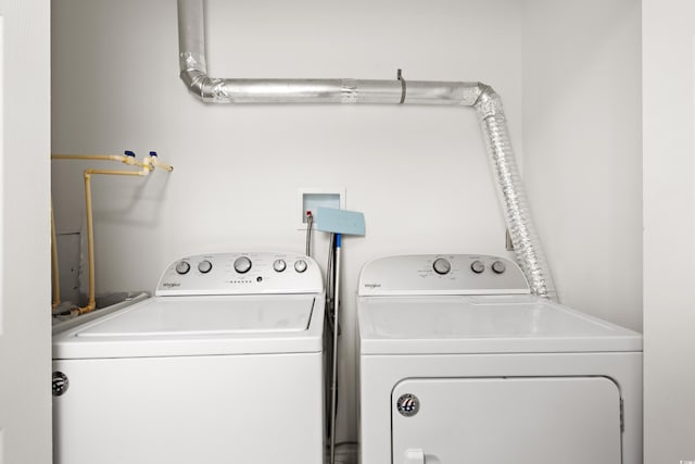 clothes washing area featuring separate washer and dryer