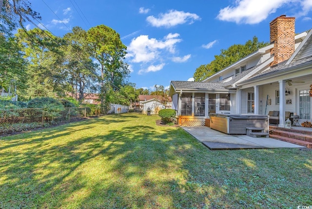 view of yard featuring a patio, a hot tub, and a sunroom